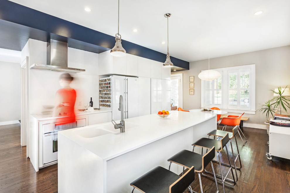 Modelo de cocina comedor contemporánea con fregadero integrado, armarios con paneles lisos, puertas de armario blancas, salpicadero blanco y electrodomésticos blancos