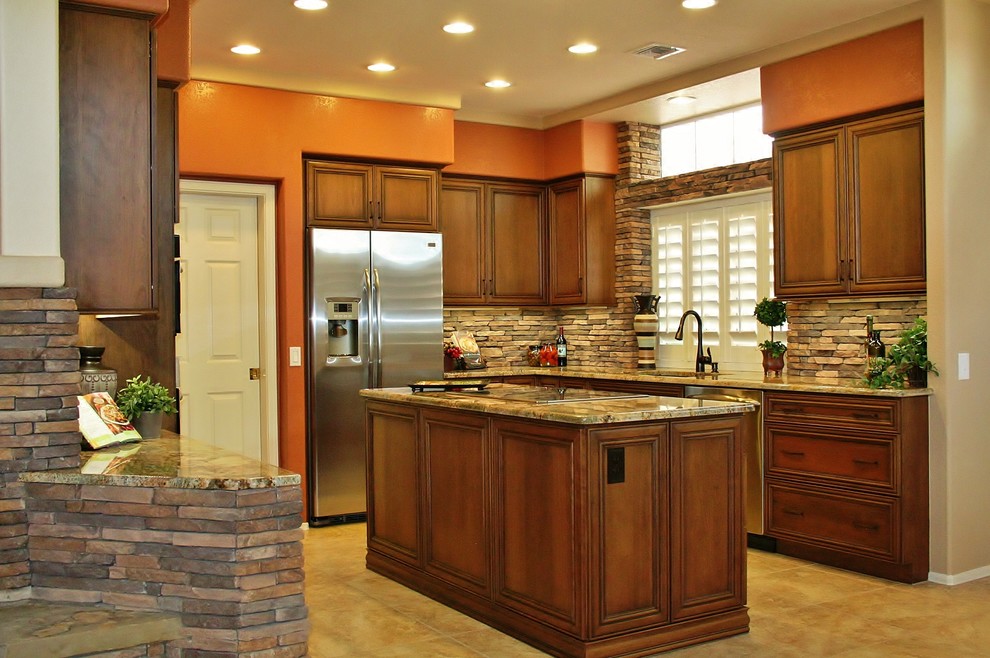 Inspiration for a mid-sized timeless u-shaped linoleum floor eat-in kitchen remodel in Phoenix with an undermount sink, granite countertops, stainless steel appliances, an island, raised-panel cabinets, dark wood cabinets, brown backsplash and stone tile backsplash