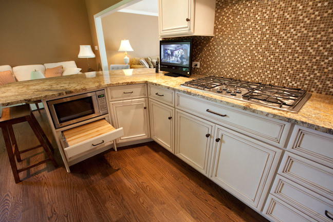 Example of a large classic galley medium tone wood floor eat-in kitchen design in Other with an undermount sink, flat-panel cabinets, white cabinets, granite countertops, multicolored backsplash, glass sheet backsplash and stainless steel appliances