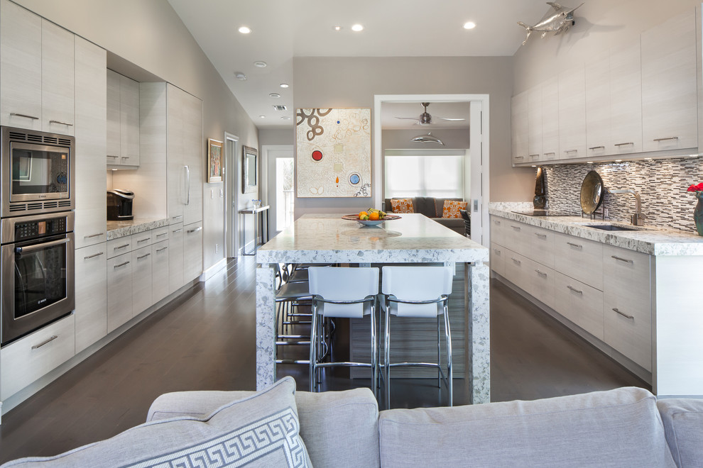 Exempel på ett mellanstort modernt kök, med en undermonterad diskho, granitbänkskiva, rostfria vitvaror, en köksö, släta luckor, flerfärgad stänkskydd, stänkskydd i stickkakel och mörkt trägolv