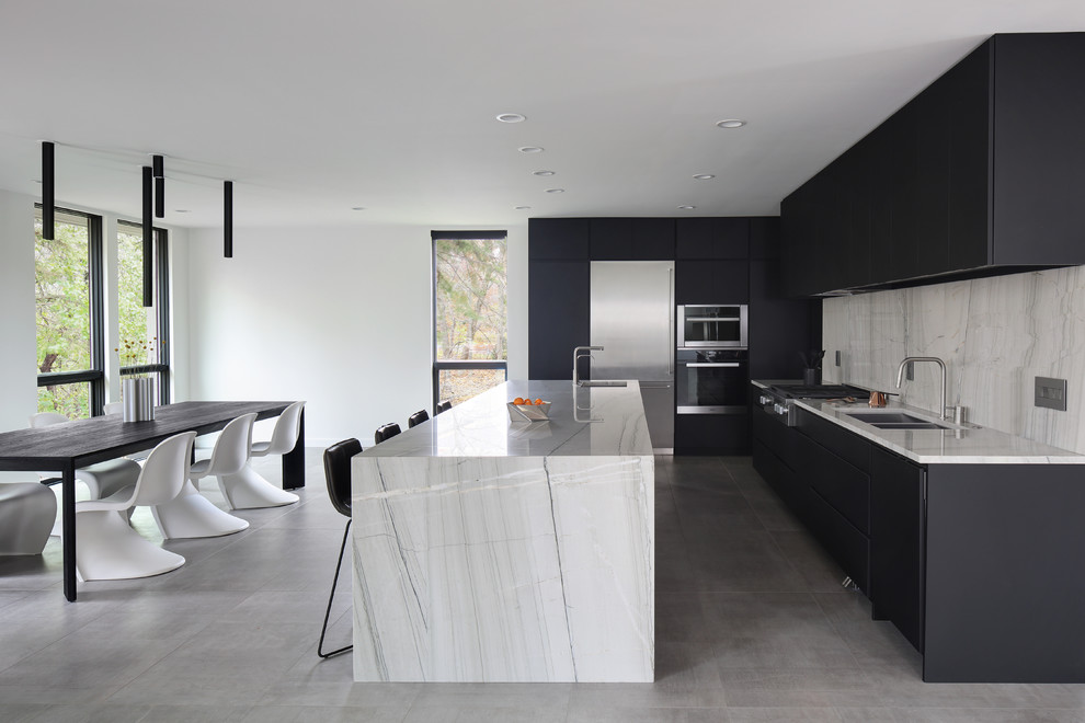 Example of a minimalist l-shaped gray floor eat-in kitchen design in Milwaukee with a double-bowl sink, flat-panel cabinets, black cabinets, white backsplash, stainless steel appliances, an island and white countertops