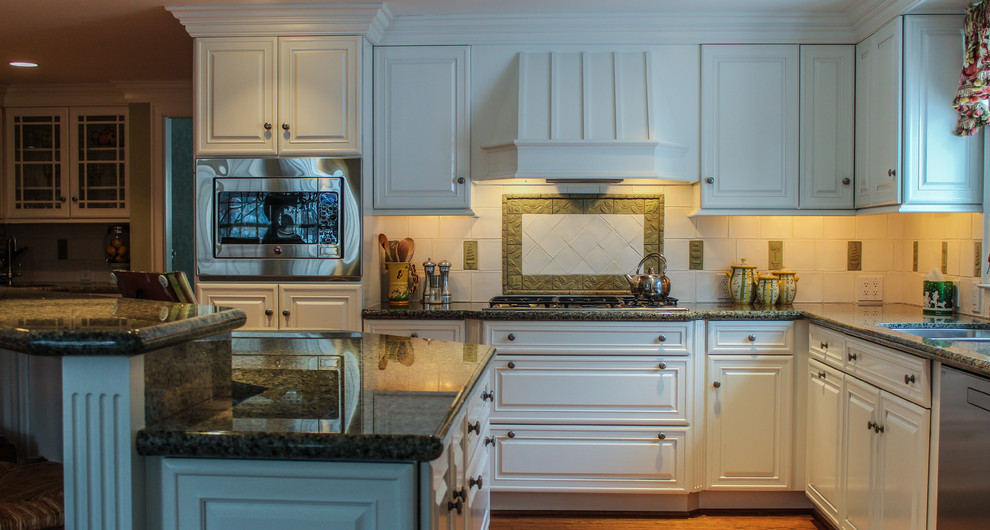 デトロイトにある広いトラディショナルスタイルのおしゃれなキッチン (白いキャビネット、白いキッチンパネル、シルバーの調理設備、ダブルシンク、レイズドパネル扉のキャビネット、無垢フローリング、茶色い床) の写真
