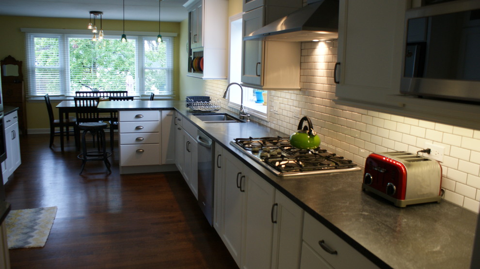 Inspiration för klassiska kök, med en undermonterad diskho, luckor med infälld panel, vita skåp, granitbänkskiva, gult stänkskydd, stänkskydd i porslinskakel och rostfria vitvaror