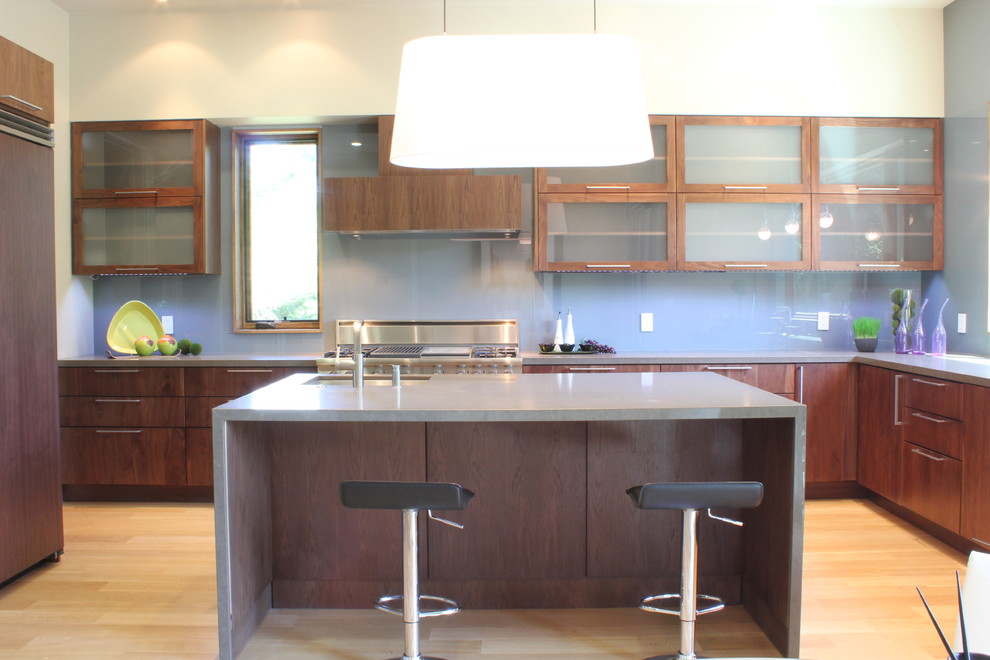 Exempel på ett mellanstort modernt kök, med en undermonterad diskho, luckor med glaspanel, skåp i mörkt trä, bänkskiva i kvarts, grått stänkskydd, stänkskydd i glaskakel, rostfria vitvaror, ljust trägolv och en köksö