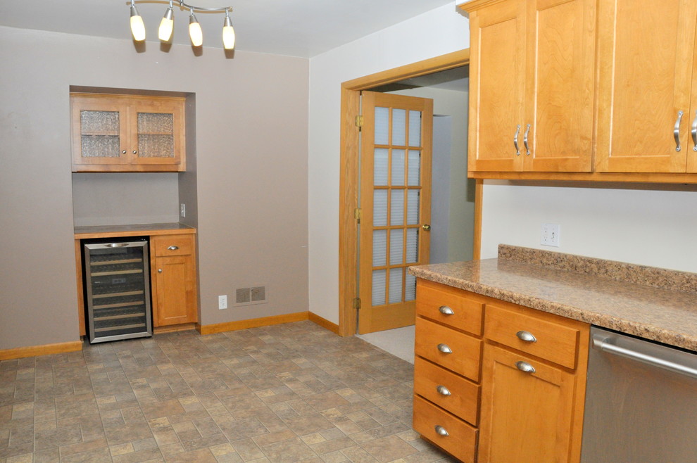Example of a transitional galley linoleum floor eat-in kitchen design in Other with a double-bowl sink, medium tone wood cabinets, laminate countertops and stainless steel appliances