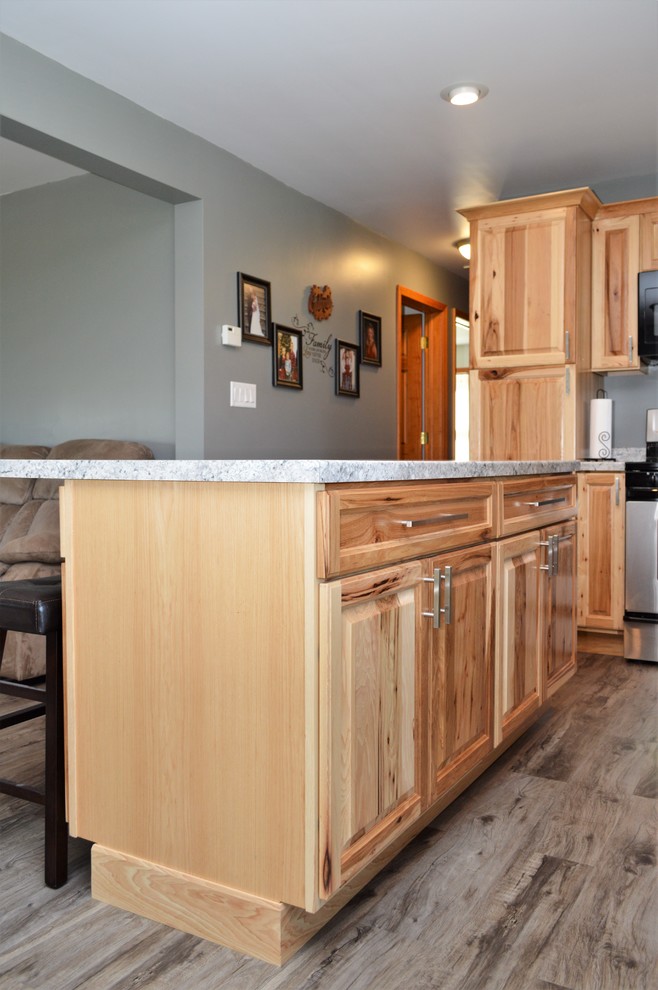 Exempel på ett mellanstort rustikt grå grått kök, med en undermonterad diskho, luckor med upphöjd panel, skåp i ljust trä, laminatbänkskiva, svarta vitvaror, laminatgolv, en köksö och brunt golv