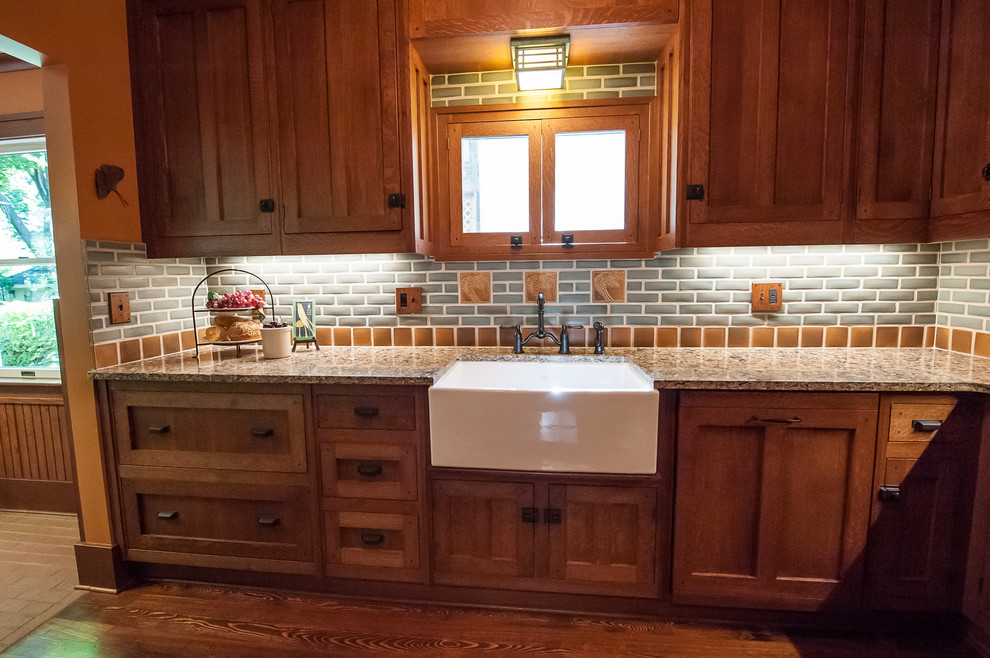Inspiration for a small classic l-shaped enclosed kitchen in Detroit with a belfast sink, beaded cabinets, medium wood cabinets, engineered stone countertops, grey splashback, metro tiled splashback, stainless steel appliances, dark hardwood flooring and no island.