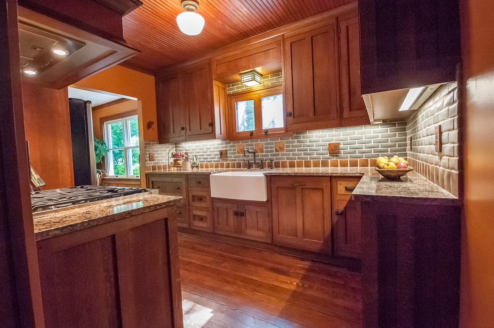 Small arts and crafts l-shaped dark wood floor enclosed kitchen photo in Detroit with a farmhouse sink, beaded inset cabinets, medium tone wood cabinets, quartz countertops, gray backsplash, subway tile backsplash, stainless steel appliances and no island