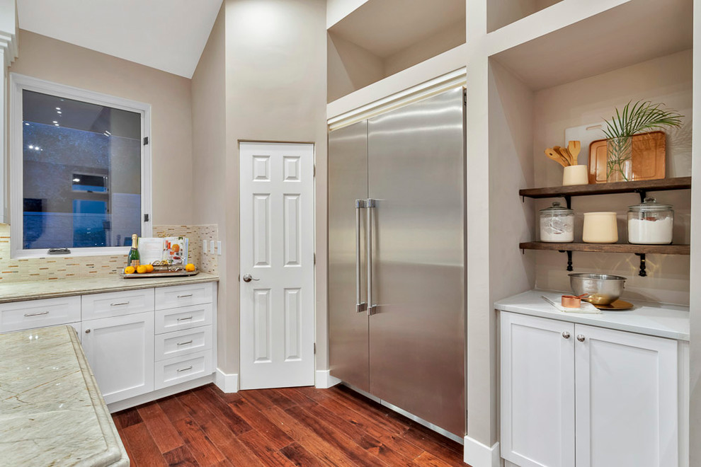Exempel på ett stort 50 tals beige beige kök, med en undermonterad diskho, skåp i shakerstil, vita skåp, granitbänkskiva, beige stänkskydd, spegel som stänkskydd, rostfria vitvaror, mellanmörkt trägolv, en köksö och brunt golv