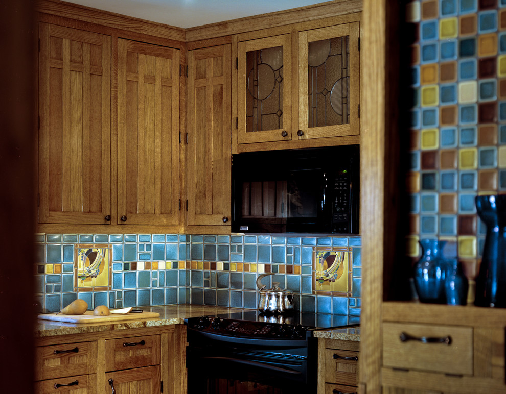 Immagine di una cucina stile americano di medie dimensioni con ante in stile shaker, ante marroni, top in granito, paraspruzzi blu, paraspruzzi con piastrelle in ceramica, elettrodomestici neri, penisola, pavimento multicolore e top beige