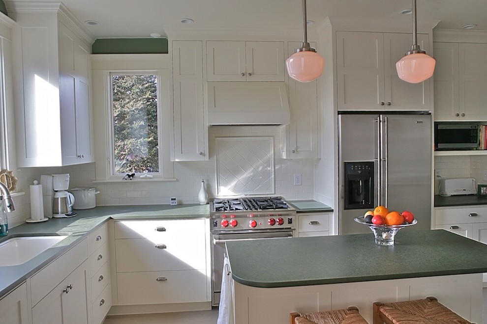 Klassische Wohnküche in L-Form mit Küchenrückwand in Weiß, Rückwand aus Metrofliesen, Küchengeräten aus Edelstahl, weißen Schränken, Schrankfronten im Shaker-Stil, Unterbauwaschbecken und Kücheninsel in Orlando