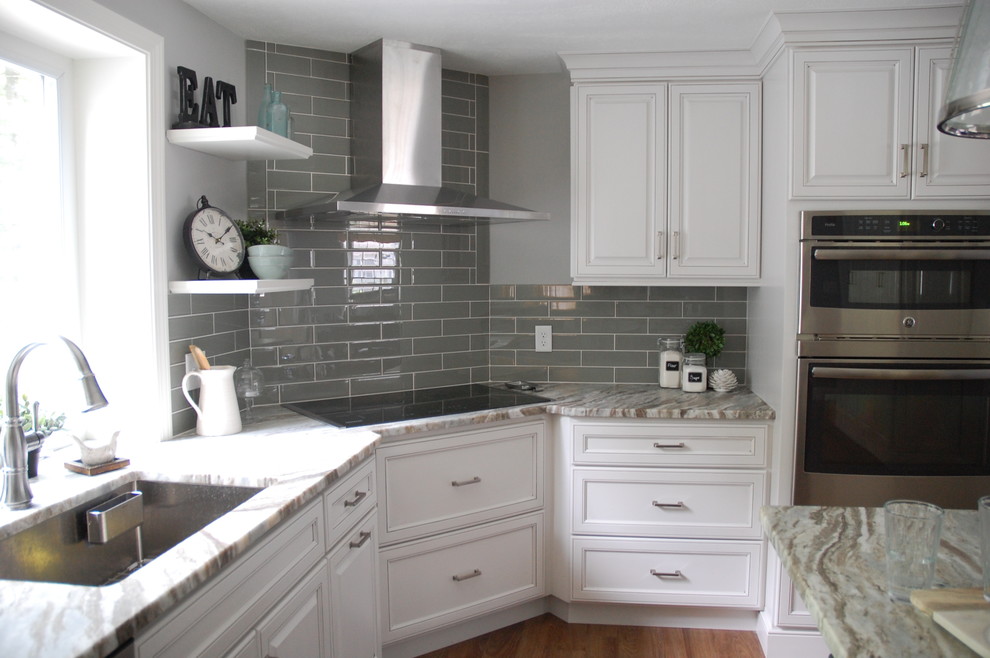 This is an example of a country kitchen in Boston with a single-bowl sink, beaded cabinets, white cabinets, quartz worktops, green splashback, glass tiled splashback, stainless steel appliances, vinyl flooring and an island.