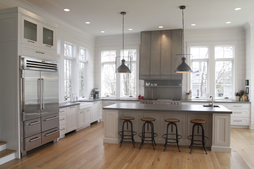 Foto på ett lantligt kök, med skåp i shakerstil, vita skåp, rostfria vitvaror och en köksö