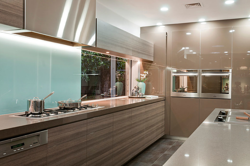 Modern u-shaped kitchen pantry in Melbourne with a submerged sink, flat-panel cabinets, brown cabinets, engineered stone countertops, glass sheet splashback, stainless steel appliances, porcelain flooring and an island.
