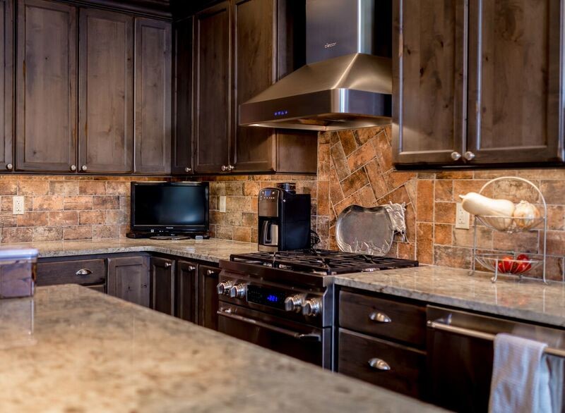 Inredning av ett rustikt stort u-kök, med skåp i shakerstil, skåp i mörkt trä, granitbänkskiva, brunt stänkskydd, stänkskydd i stenkakel, rostfria vitvaror, mellanmörkt trägolv, en köksö och brunt golv
