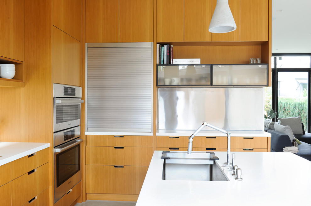 Bild på ett mellanstort funkis vit vitt kök, med en undermonterad diskho, släta luckor, skåp i ljust trä, bänkskiva i koppar, stänkskydd med metallisk yta, stänkskydd i metallkakel, integrerade vitvaror, betonggolv, en köksö och grått golv