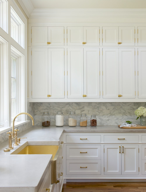 transitional medium tone wood floor open concept kitchen remodel in New York with a farmhouse sink, shaker cabinets, white cabinets, white backsplash, marble countertops, an island and marble backsplash