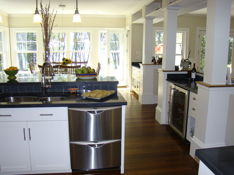 Foto på ett mellanstort funkis kök, med en dubbel diskho, skåp i shakerstil, vita skåp, bänkskiva i betong, grått stänkskydd, stänkskydd i glaskakel, rostfria vitvaror, mellanmörkt trägolv och en köksö