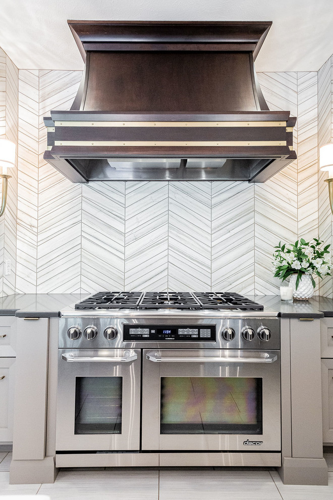 Inspiration for a large modern u-shaped porcelain tile and gray floor kitchen remodel in Other with a farmhouse sink, gray cabinets, marble countertops, gray backsplash, marble backsplash, stainless steel appliances, an island and multicolored countertops