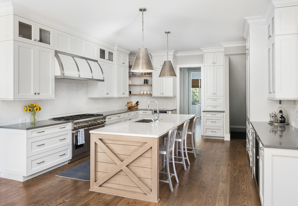 Example of a large transitional u-shaped brown floor and dark wood floor eat-in kitchen design in Chicago with a single-bowl sink, recessed-panel cabinets, white cabinets, quartz countertops, white backsplash, subway tile backsplash, paneled appliances, an island and gray countertops