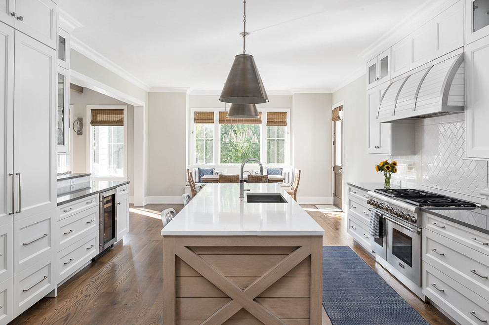 Eat-in kitchen - large transitional u-shaped medium tone wood floor and brown floor eat-in kitchen idea in Chicago with a single-bowl sink, recessed-panel cabinets, white cabinets, quartz countertops, white backsplash, subway tile backsplash, paneled appliances, an island and gray countertops