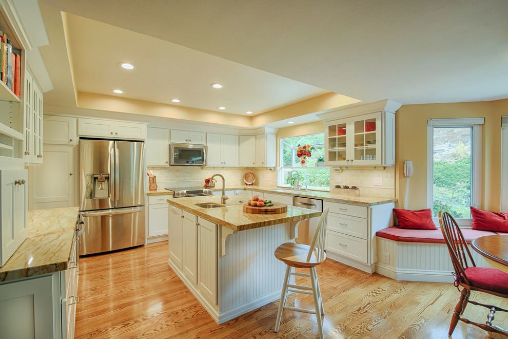 Photo of a medium sized traditional u-shaped open plan kitchen in San Francisco with a submerged sink, flat-panel cabinets, white cabinets, granite worktops, yellow splashback, ceramic splashback, stainless steel appliances, light hardwood flooring and an island.
