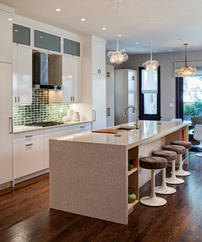 Open concept kitchen - mid-sized contemporary u-shaped dark wood floor open concept kitchen idea in Chicago with an undermount sink, flat-panel cabinets, white cabinets, solid surface countertops, green backsplash, ceramic backsplash, paneled appliances and an island