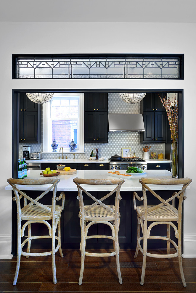 Photo of a medium sized classic galley kitchen in Toronto with recessed-panel cabinets, black cabinets, engineered stone countertops, white splashback, stainless steel appliances and dark hardwood flooring.