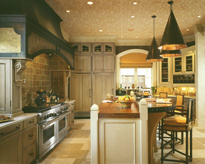 Inredning av ett medelhavsstil avskilt, mellanstort linjärt kök, med en undermonterad diskho, luckor med profilerade fronter, vita skåp, träbänkskiva, brunt stänkskydd, stänkskydd i porslinskakel, rostfria vitvaror, travertin golv, en köksö och beiget golv