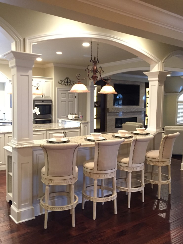 Huge ornate u-shaped kitchen pantry photo in Other with an undermount sink, raised-panel cabinets, white cabinets, granite countertops, white backsplash, stainless steel appliances and two islands