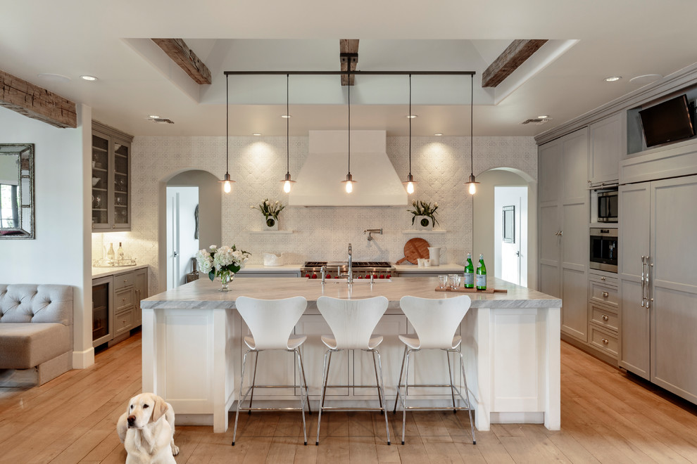 Klassische Küche mit Schrankfronten im Shaker-Stil, grauen Schränken, Elektrogeräten mit Frontblende, hellem Holzboden, Kücheninsel und grauer Arbeitsplatte in Phoenix
