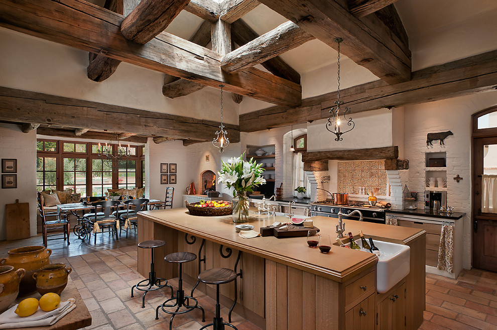 Cette photo montre une cuisine américaine parallèle en bois brun avec un plan de travail en béton et un évier de ferme.