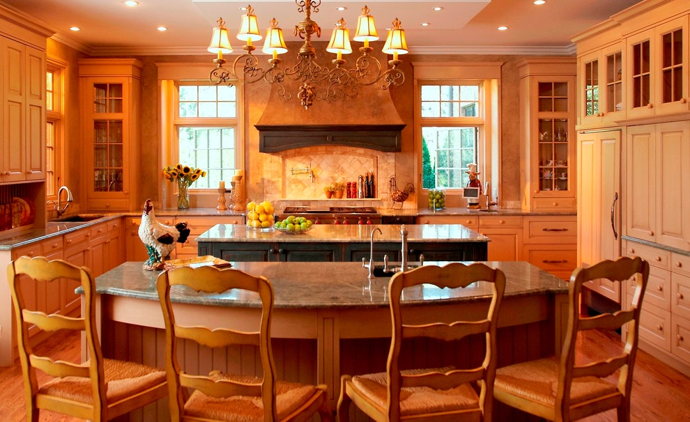 На фото: п-образная кухня с фасадами с выступающей филенкой, светлыми деревянными фасадами, бежевым фартуком, техникой под мебельный фасад и зеленой столешницей с