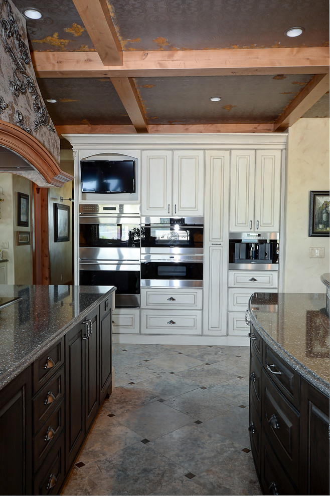 Huge tuscan kitchen photo in Other with raised-panel cabinets, white cabinets, quartz countertops, paneled appliances and two islands