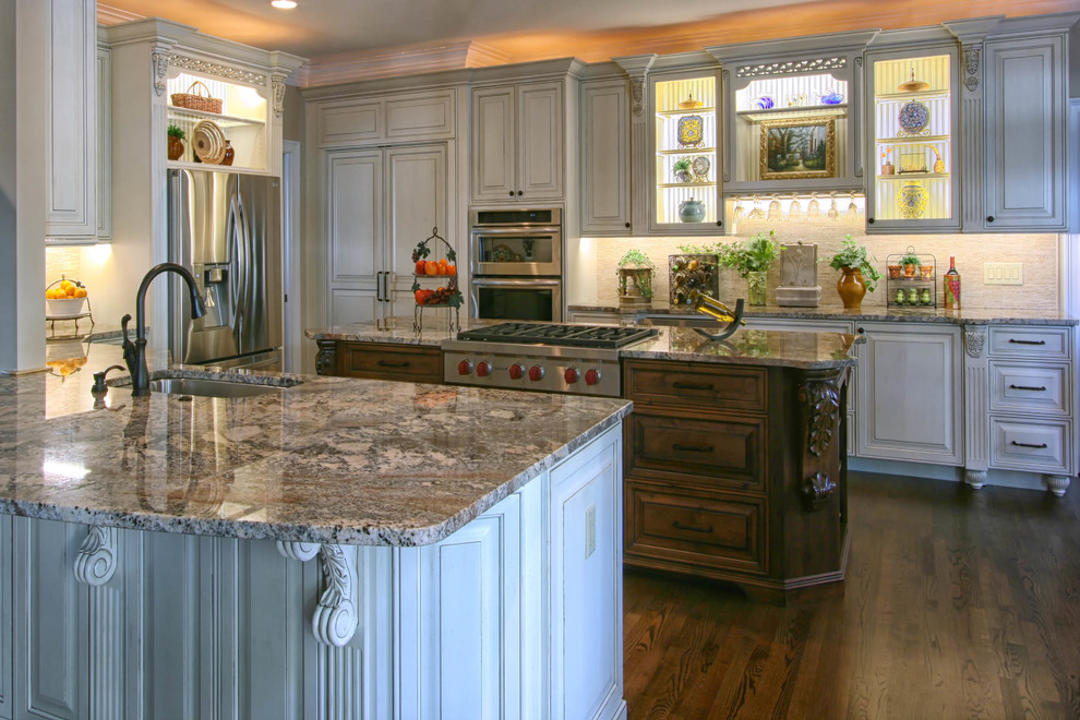 Inspiration for a mid-sized timeless u-shaped medium tone wood floor eat-in kitchen remodel in Charlotte with an undermount sink, raised-panel cabinets, white cabinets, granite countertops, white backsplash, stainless steel appliances, an island and stone tile backsplash