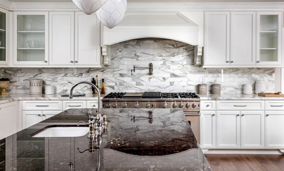 Example of a large french country u-shaped medium tone wood floor and brown floor eat-in kitchen design in Los Angeles with recessed-panel cabinets, white cabinets, multicolored backsplash, marble backsplash, stainless steel appliances, an island, multicolored countertops and an undermount sink