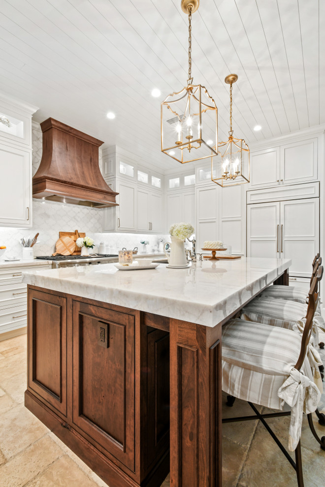 Foto på ett mellanstort vintage vit kök, med en undermonterad diskho, luckor med profilerade fronter, vita skåp, bänkskiva i kvartsit, vitt stänkskydd, stänkskydd i marmor, integrerade vitvaror, kalkstensgolv, en köksö och beiget golv