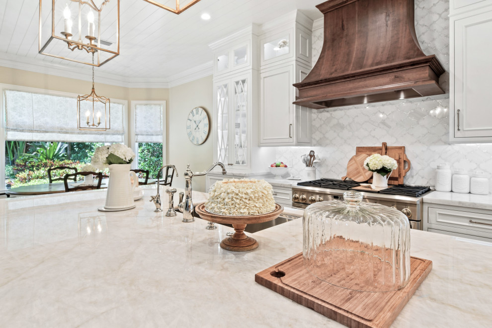 Mid-sized french country l-shaped limestone floor, beige floor and wood ceiling open concept kitchen photo in Other with an undermount sink, beaded inset cabinets, white cabinets, quartzite countertops, white backsplash, marble backsplash, paneled appliances, an island and white countertops