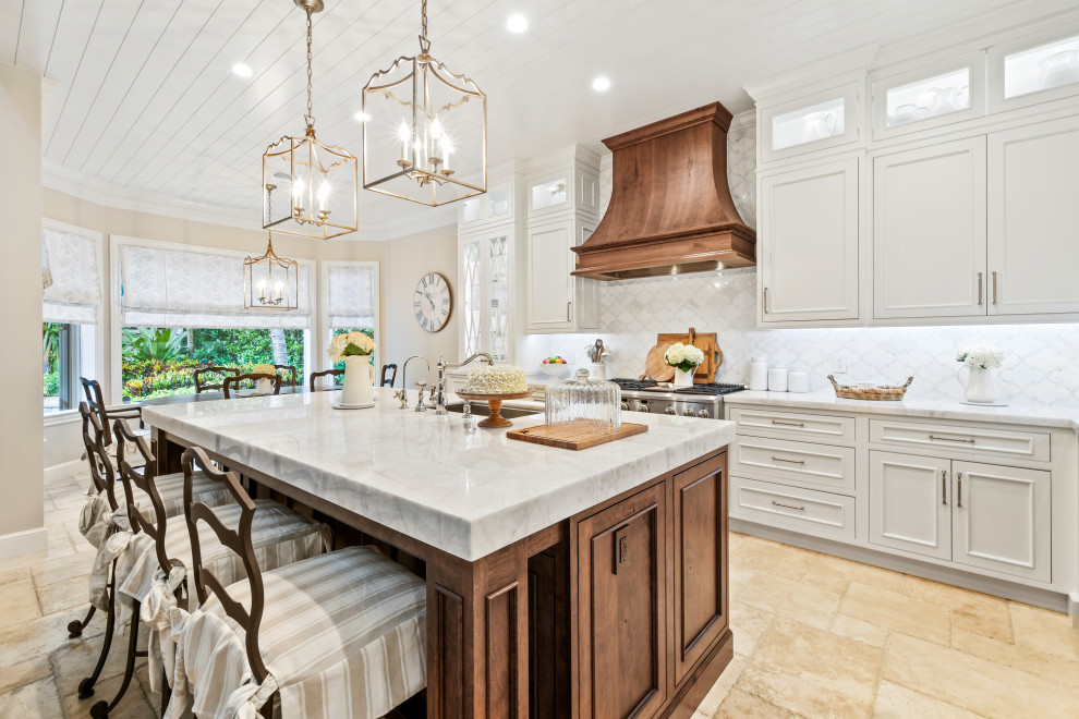 Example of a mid-sized french country l-shaped limestone floor, beige floor and wood ceiling open concept kitchen design in Other with an undermount sink, beaded inset cabinets, white cabinets, quartzite countertops, white backsplash, marble backsplash, paneled appliances, an island and white countertops