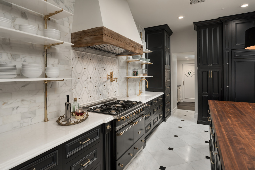 Lantlig inredning av ett mycket stort flerfärgad flerfärgat kök, med en rustik diskho, luckor med infälld panel, svarta skåp, träbänkskiva, flerfärgad stänkskydd, stänkskydd i marmor, integrerade vitvaror, marmorgolv, en köksö och flerfärgat golv
