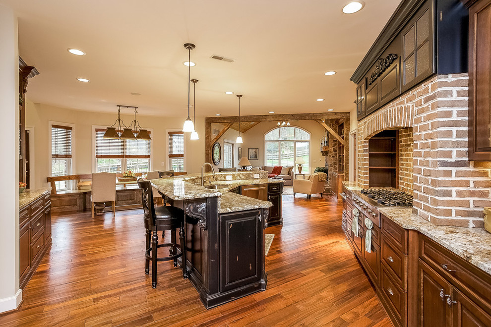 Example of a large classic u-shaped medium tone wood floor and brown floor eat-in kitchen design in Baltimore with an undermount sink, raised-panel cabinets, dark wood cabinets, granite countertops, brown backsplash, brick backsplash, stainless steel appliances and an island