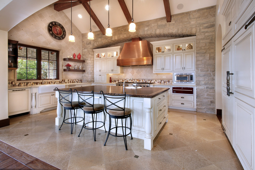 Inspiration for a large timeless u-shaped ceramic tile and beige floor open concept kitchen remodel in Orange County with a farmhouse sink, raised-panel cabinets, white cabinets, beige backsplash, ceramic backsplash, stainless steel appliances and an island
