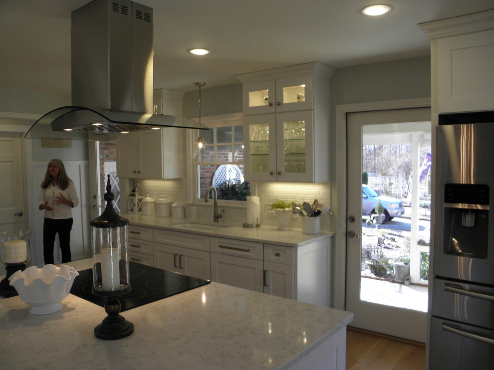 Bild på ett mellanstort lantligt kök, med en undermonterad diskho, skåp i shakerstil, vita skåp, bänkskiva i kvarts, stänkskydd i keramik, rostfria vitvaror, ljust trägolv och en köksö