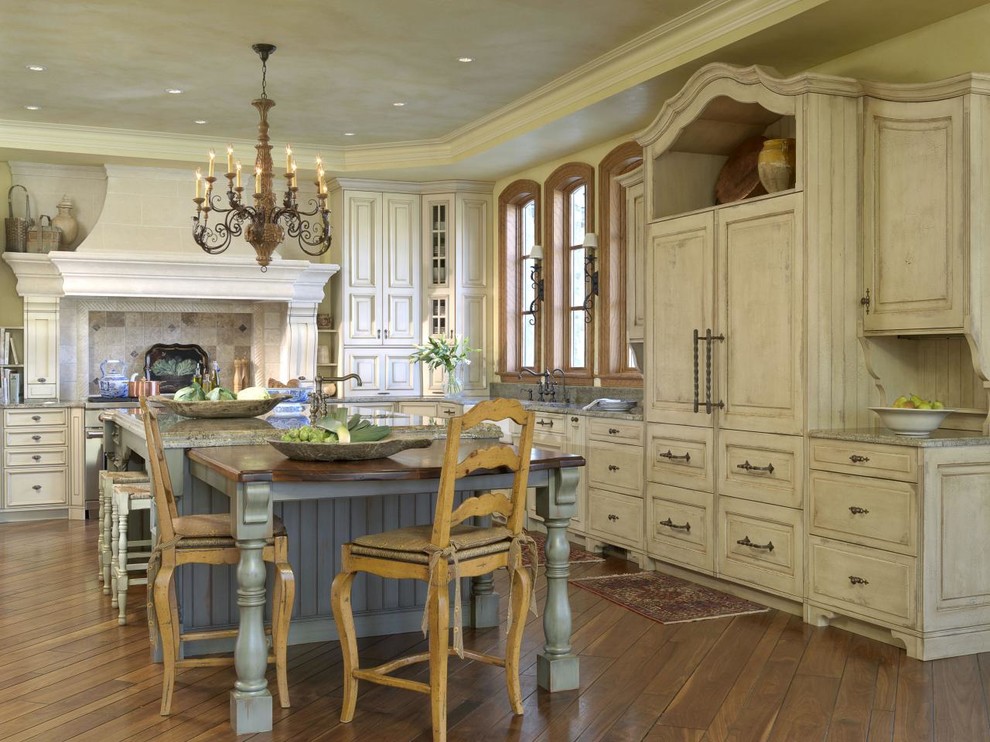 Große Küche in L-Form mit profilierten Schrankfronten, Schränken im Used-Look, braunem Holzboden und Kücheninsel in New York