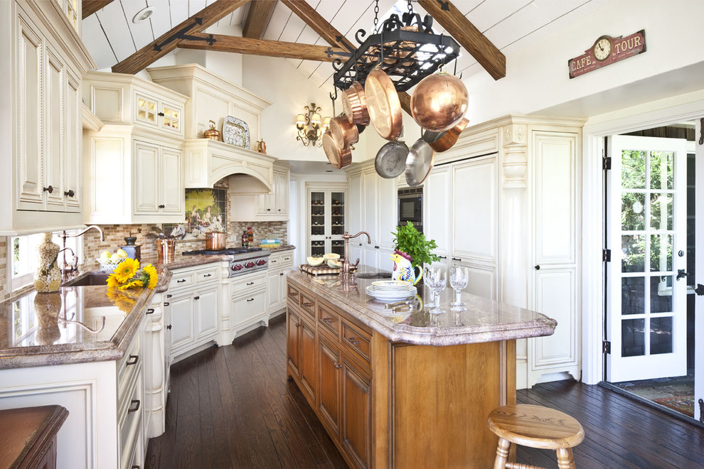 U-shaped kitchen/diner in Los Angeles with a submerged sink, raised-panel cabinets, beige cabinets, multi-coloured splashback, matchstick tiled splashback, stainless steel appliances, dark hardwood flooring and an island.