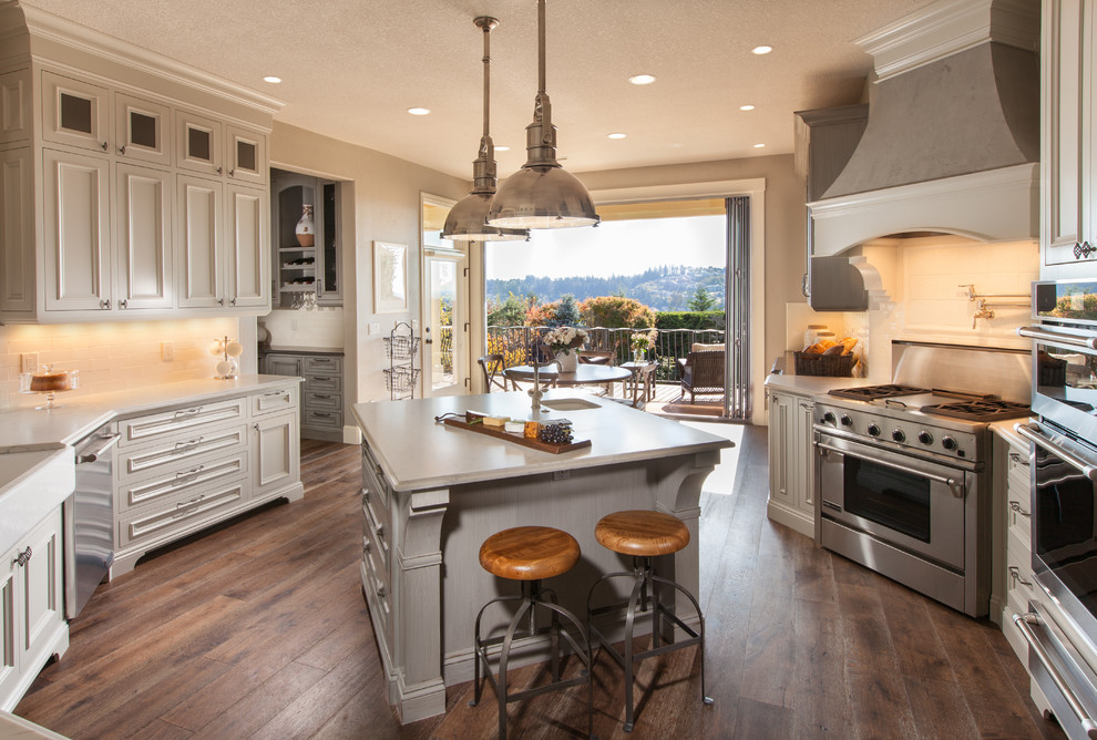 Inspiration for a large french country u-shaped medium tone wood floor and brown floor enclosed kitchen remodel in Portland with stainless steel appliances, an island, an undermount sink, beaded inset cabinets, white cabinets, quartzite countertops, white backsplash and subway tile backsplash