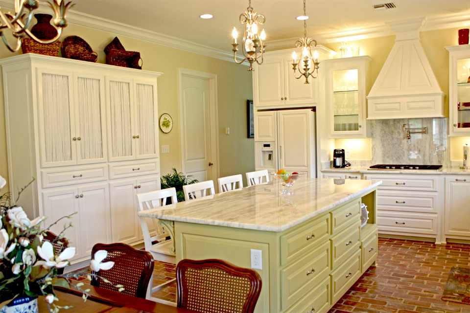 Inredning av ett klassiskt stort kök, med luckor med upphöjd panel, vita skåp, marmorbänkskiva, grått stänkskydd, stänkskydd i stenkakel, rostfria vitvaror, tegelgolv och en köksö