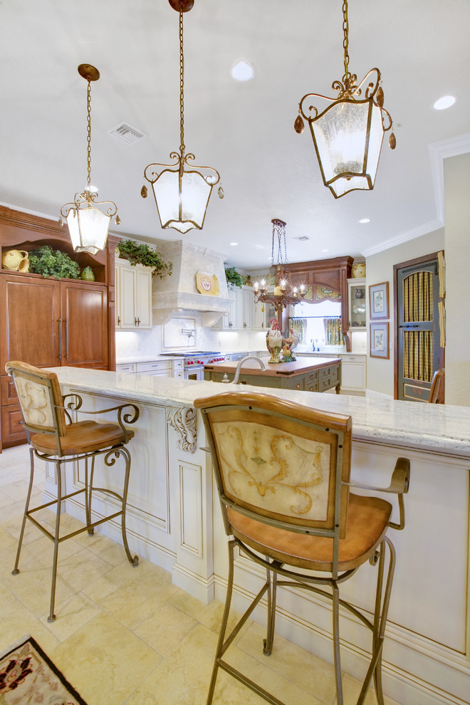 Inspiration for a french country kitchen remodel in Orlando with raised-panel cabinets and paneled appliances