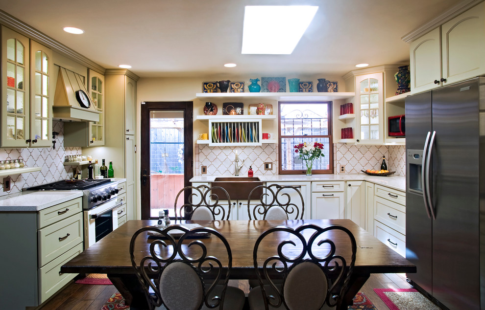 Wohnküche in U-Form mit Landhausspüle, Schrankfronten mit vertiefter Füllung, weißen Schränken, Küchenrückwand in Weiß und Küchengeräten aus Edelstahl in Austin