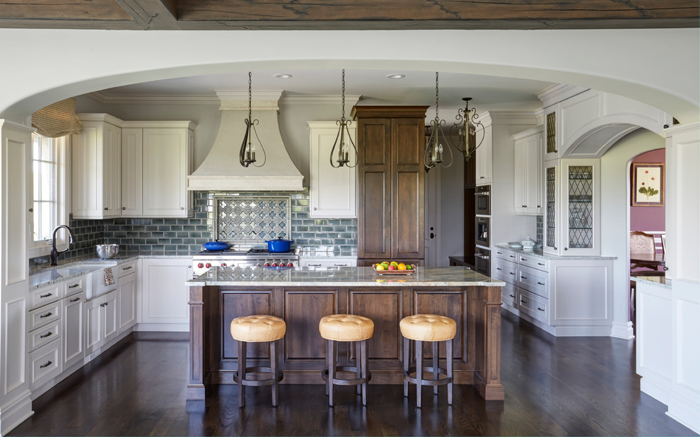Idéer för att renovera ett stort vintage grå grått kök, med en rustik diskho, luckor med infälld panel, vita skåp, granitbänkskiva, grönt stänkskydd, stänkskydd i keramik, rostfria vitvaror, mörkt trägolv, en köksö och brunt golv